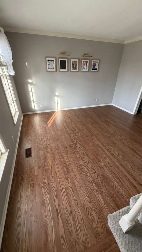 Warm hardwood floor installed in a bright dining room